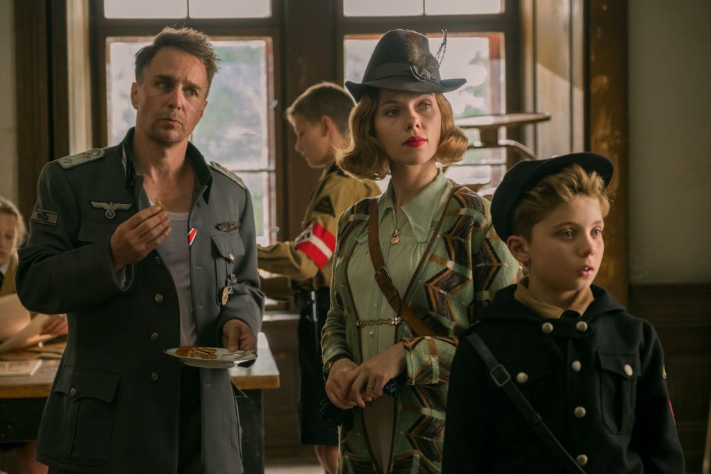 (From L-R): Sam Rockwell, Scarlett Johansson and Roman Griffin Davis in the film JOJO RABBIT. Photo by Larry Horricks. © 2019 Twentieth Century Fox Film Corporation All Rights Reserved